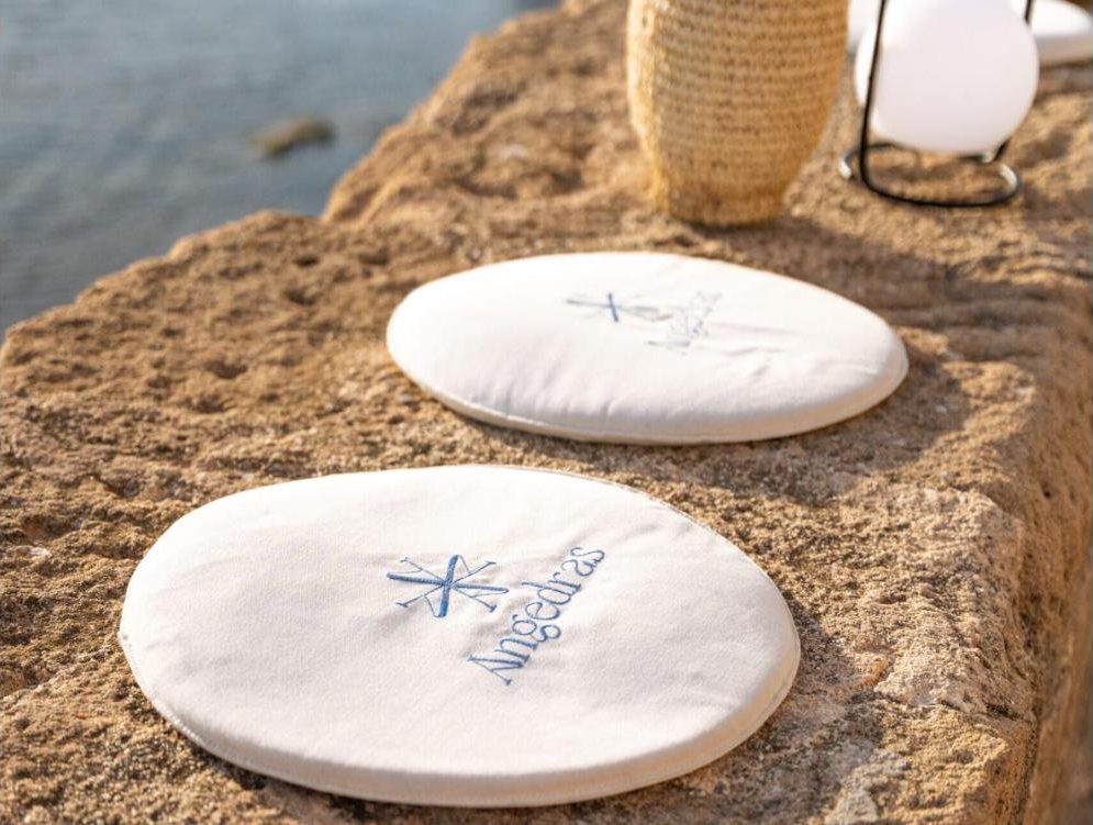 Cuscini ricamati con il logo Angedras sul muretto dei Bastioni